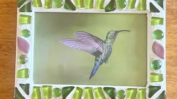 Hummingbird image framed with colorful mosaic.