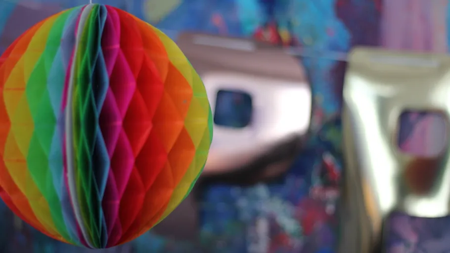 Bunte Papierkugel mit unscharfen Hintergrundbuchstaben.