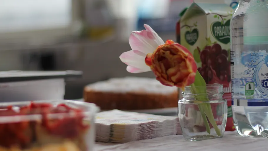 Tulpe im Glas auf Tisch mit Getränken.