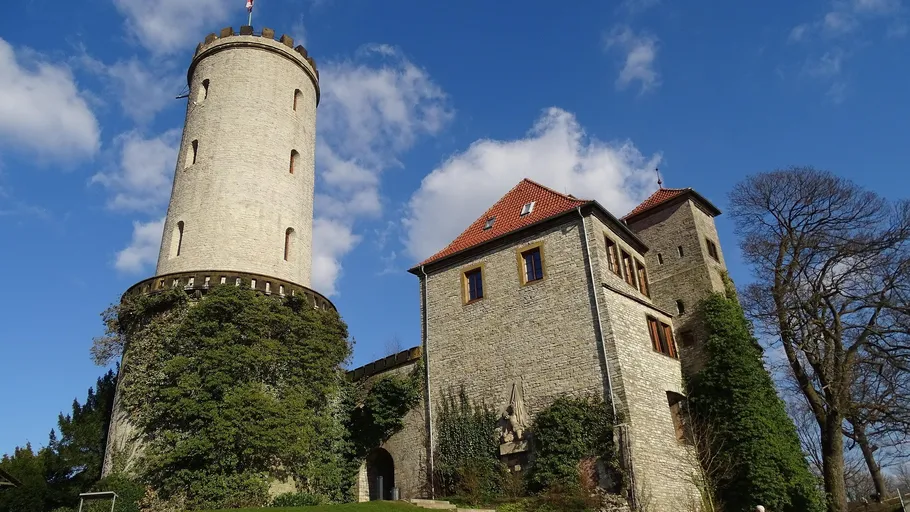 Burg mit rundem Turm, blauer Himmel Hintergrund.
