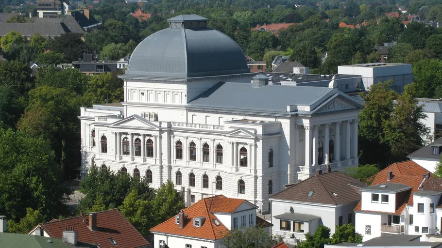 Large white classical building surrounded by trees.