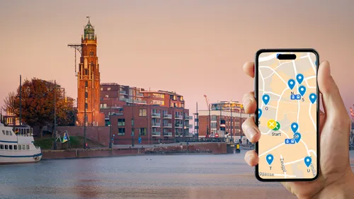 Hand hält Handy mit Karten-App, Stadtlandschaft am Wasser.
