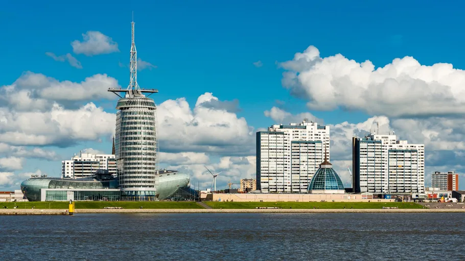 Moderne Gebäude an einem Fluss mit Wolken.