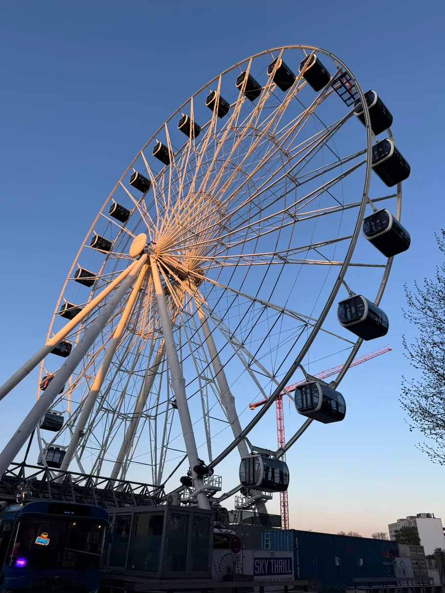Ferris wheel with gondolas against clear blue sky.
