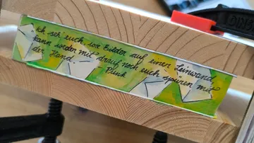 Wood clamped with handwritten note attached.