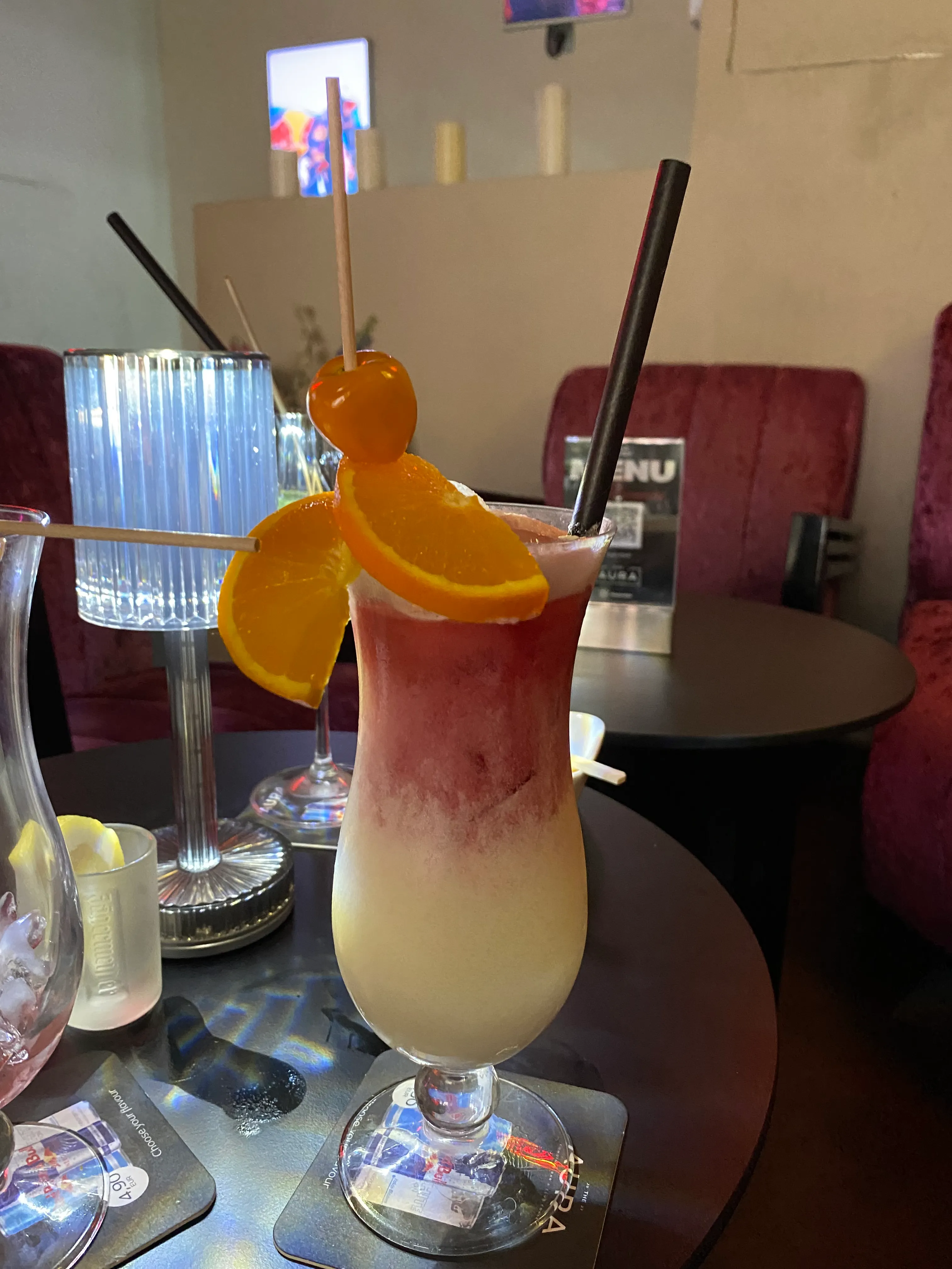 Obstcocktail mit Garnitur auf Lounge-Tisch.