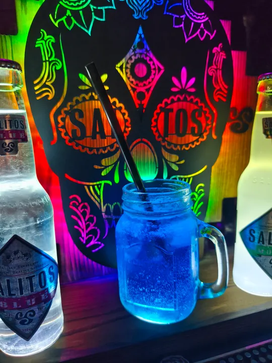 Colorful skull background with beverages and straw.