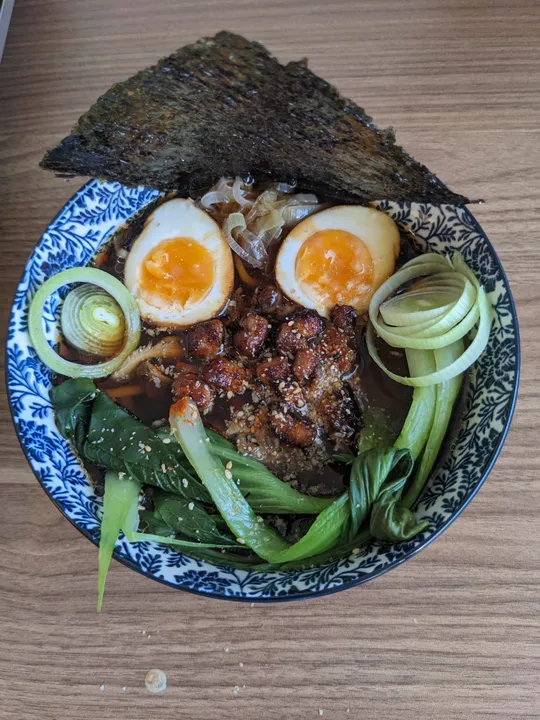 Ramen bowl with eggs, vegetables, and seaweed.