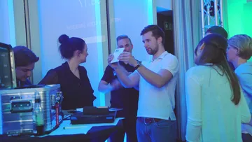 People gather around a table at an event.
