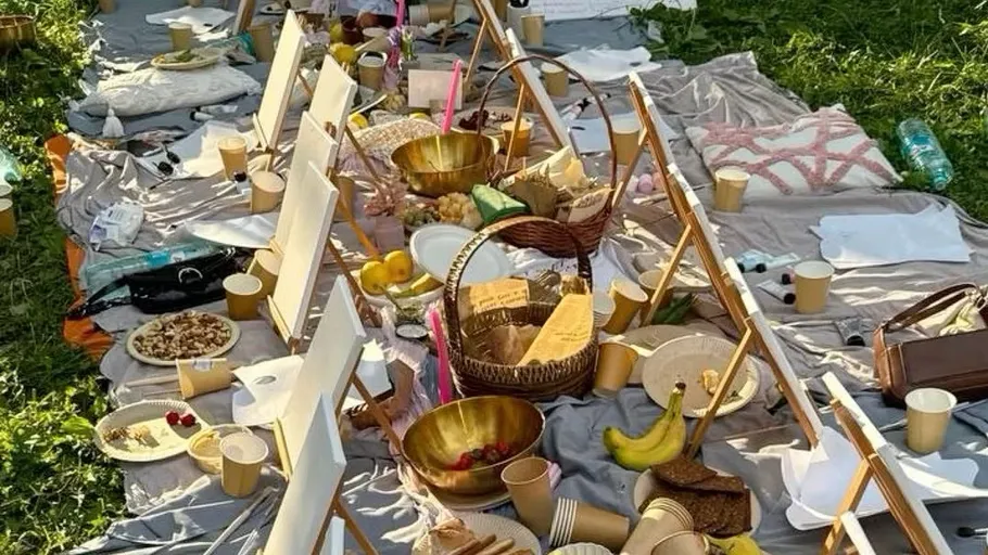 Kunstmaterialien und Snacks auf Picknickdecken im Freien.