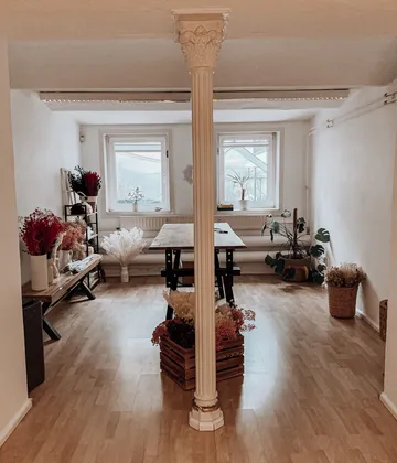 Column divides room with plants and table.