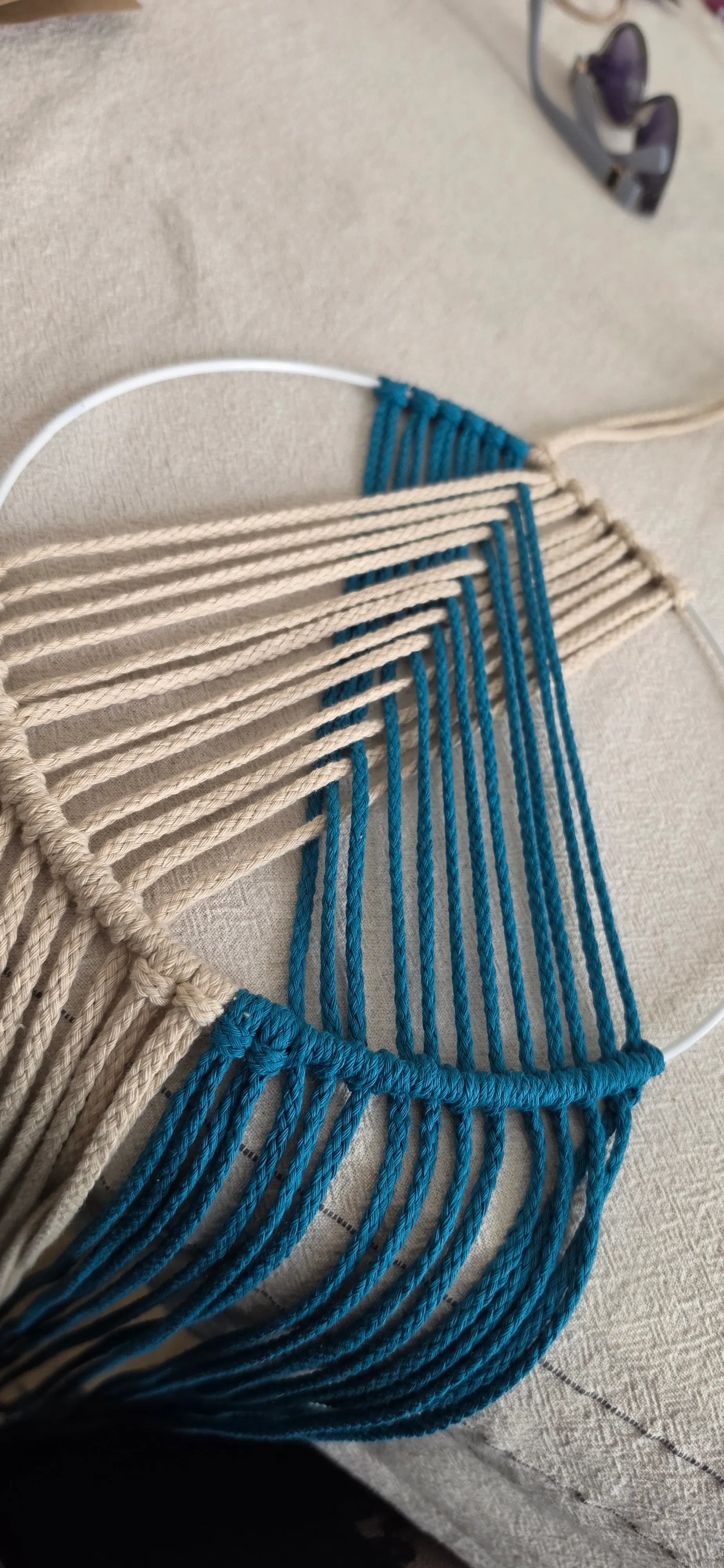Makramee-Muster mit weißen und blauen Fäden.