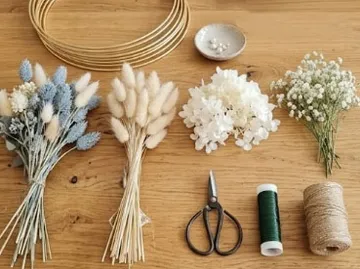 Getrocknete Blumen, Schere, Schnur auf Holztisch.