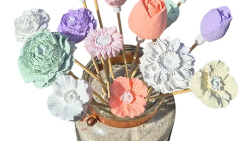 Colorful paper flowers in a glass jar.