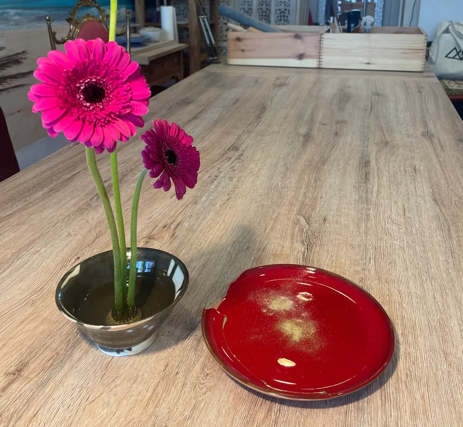 Pinke Blumen in Vase auf Holztisch.