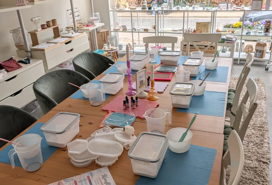Bastelwerkstatt-Tisch mit Materialien angeordnet.