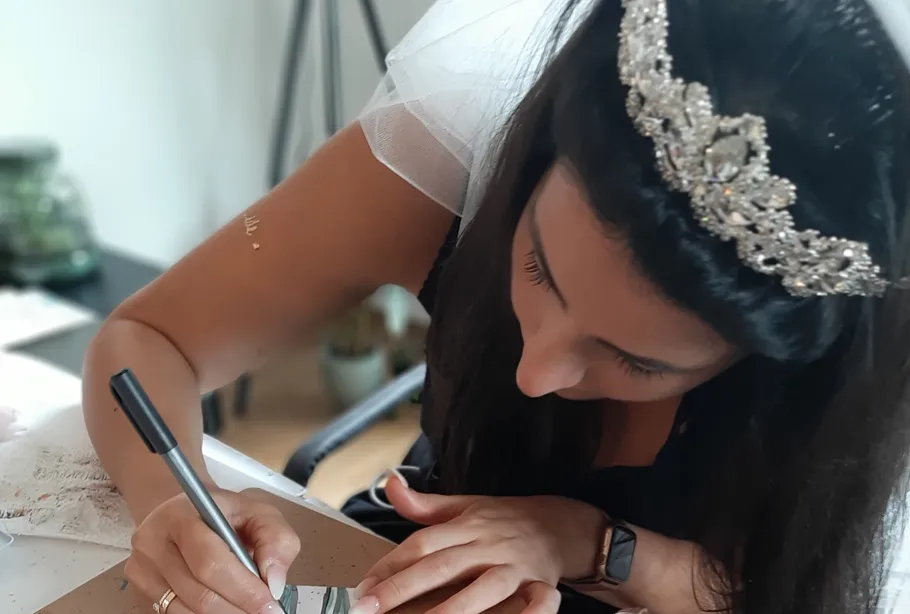 Bride writing at a desk with a tiara.