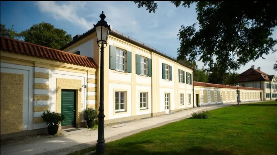 Yellow building with green shutters, sunny garden.