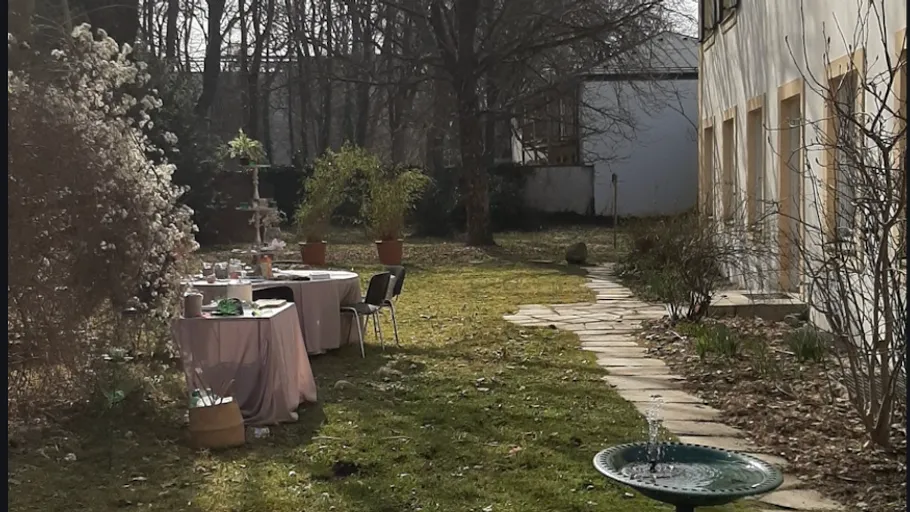 Garden with table, chairs, and fountain.