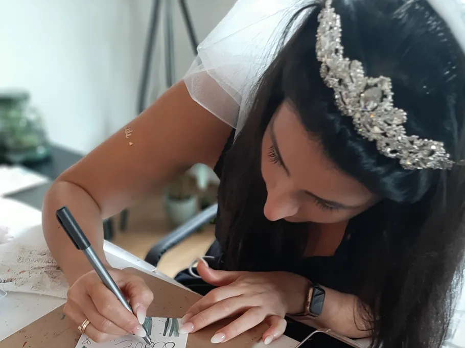 Bride writing on a card at a table.