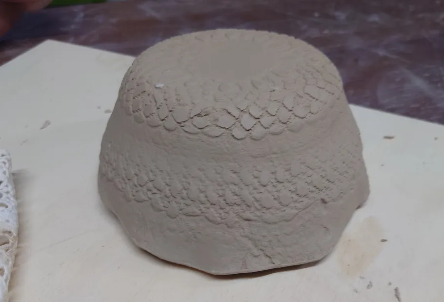 Inverted clay bowl with textured pattern.