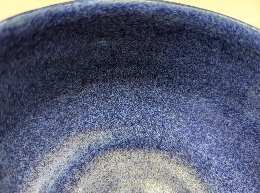 Blue bowl with speckled texture, close-up view.