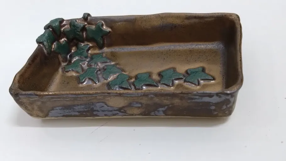 Rechteckige Keramikschale mit Blätterdesigns.