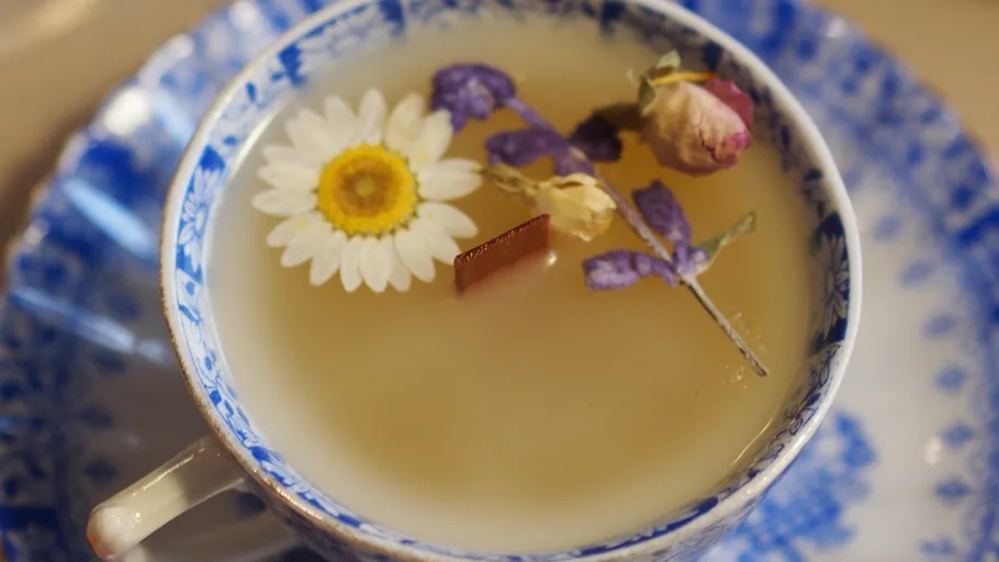 Floral tea in blue-patterned cup and saucer.