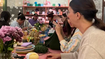 People knitting in a cozy craft room.