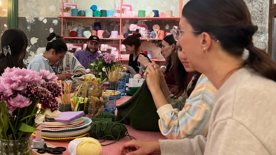 Personen stricken in einem gemütlichen Bastelzimmer.