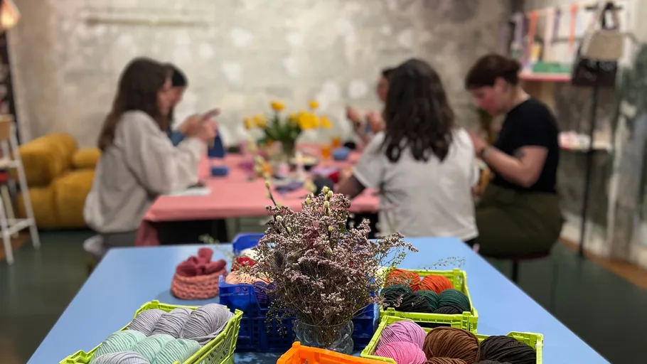 People crafting at a colorful yarn workshop.