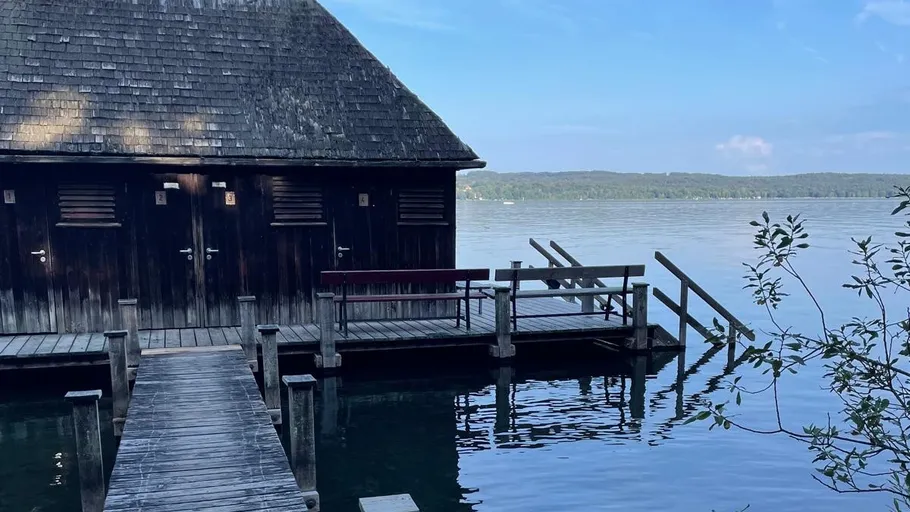Wooden boathouse by calm, blue lake.