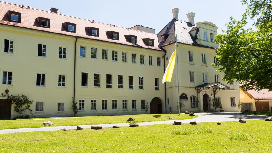 Großes historisches Gebäude mit gelber Fahne draußen.
