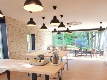 Küchenstudio mit Mischgeräten auf Holztischen, hell und modern.
