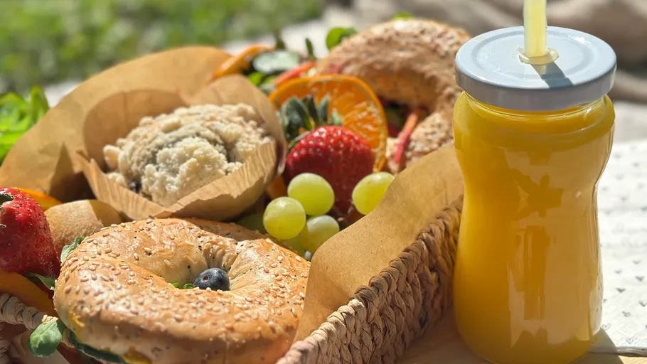 Bagels, Obst und Saft in einem Picknickkorb.