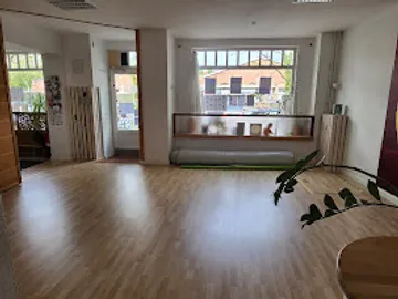 Geräumiger Raum mit Holzboden und großem Fenster.