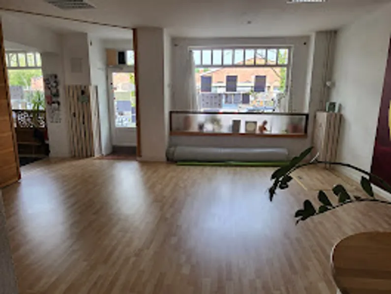 Geräumiger Raum mit Holzboden und großem Fenster.