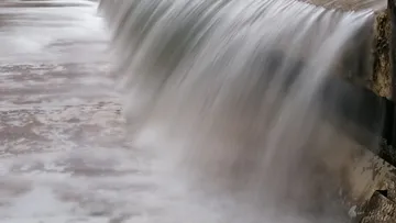 Water flowing over a small dam.