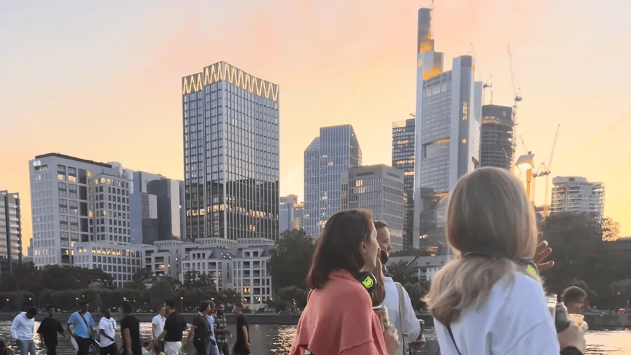 People enjoying a sunset near city skyline.