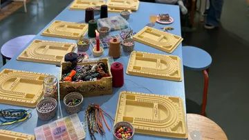 Beading supplies arranged on a blue table.