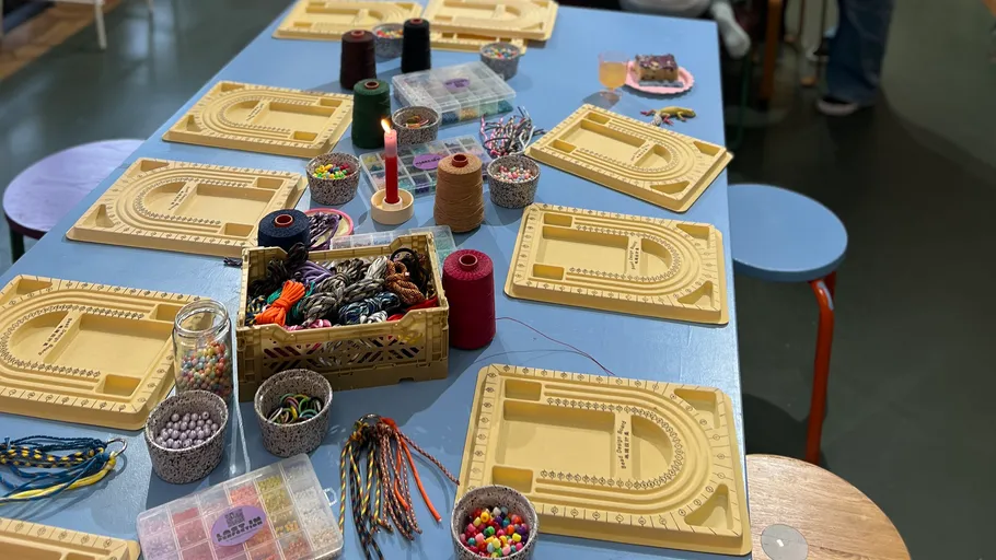 Beading supplies arranged on a blue table.