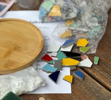Tile pieces and wooden tray on table.