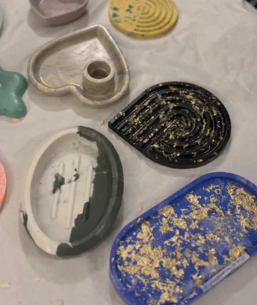 Bunte Harzschalen mit Goldflocken ausgestellt.