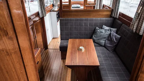 Gemütliches Bootsinnere mit Holzmöbeln.