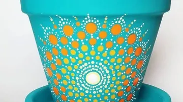 Türkiser Topf mit orange-weißem Punktmuster.