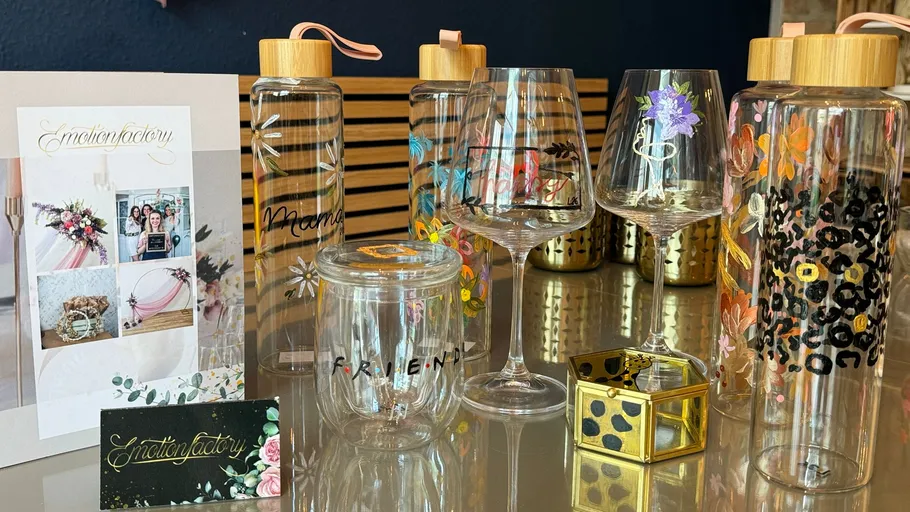 Dekorierte Flaschen und Gläser auf Ausstellungstisch.