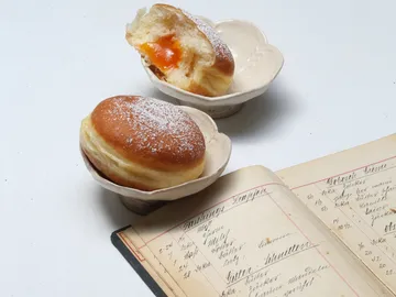 A piece of pastry with powdered sugar and apricot filling on a plate.