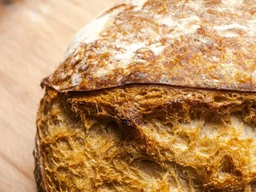 Close-up of crusty bread on wooden surface.