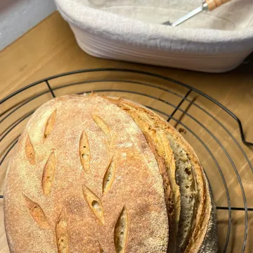 Loaf of bread cooling on a rack.