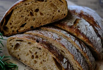 Sliced sourdough bread on wooden surface.